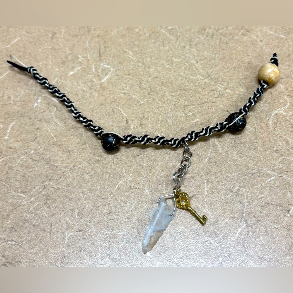 Handmade hemp bracelet with quartz and key embellishment.